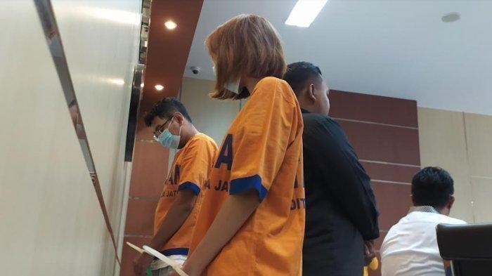 Pelaku dalam video kebaya merah ACS dan AH saat digelandang oleh penyidik Subdit V Cyber Crime Ditreskrimsus Polda Jatim di Gedung Humas Mapolda Jatim. ACS merupakan warga Surabaya yang menjadi pemeran pria dalam video Kebaya Merah. Sementara si pemeran wanita berkebaya merah, AH, merupakan warga Malang. (Tribun Jatim/Luhur Pambudi)