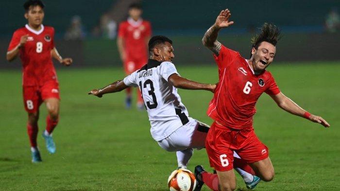 Pesepak bola Timnas Indonesia Marc Klok (kanan) terjatuh setelah dilanggar pesepakbola Timnas Timor Leste Gumario Da Silva dalam laga lanjutan Grup A Sepak Bola SEA Games 2021 Vietnam di Stadion Viet Tri, Phu Tho, Vietnam, Selasa (10/5/2022).