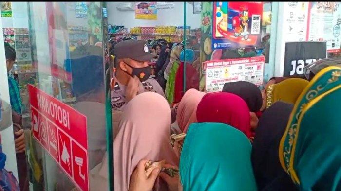 Pihak Kepolisian terlihat berjaga saat antrean emak-emak tengah berdesak-desakan membeli minyak goreng di Alfamidi Wawotobi Kabupaten Konawe, pada Rabu (9/3/2022)