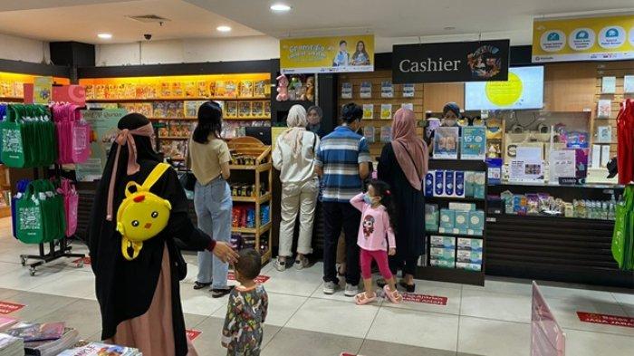 Customer Gramedia menerapkan physical distancing saat melakukan pembayaran di kasir