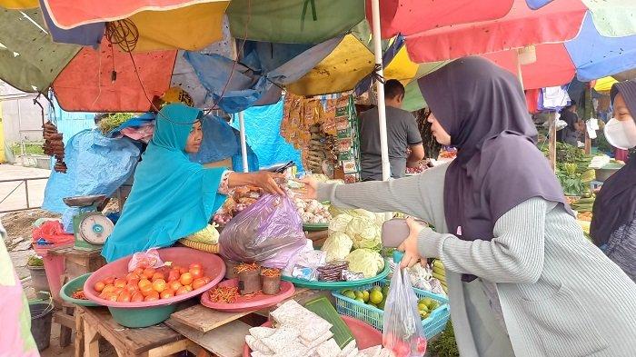 Tampak pedagang di pasar tradisional di Kendari, Provinsi Sultra, melayani seorang pembeli, Minggu (12/6/2022). Harga bahan pokok di tempat ini mengalami kenaikan, termasuk bawang dan cabai.