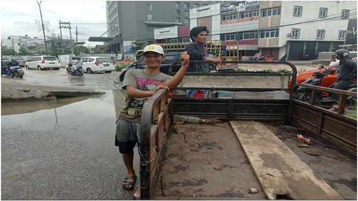 Banjir Palembang, Sukri menyewakan tumpangan bagi pengendara motor yang melintas di lokasi banjir Jl R Sukamto Palembang, Kamis (6/10/2022).