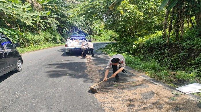 Personil Satlantas Polres OKU Selatan menaburi ceceran minyak di Jalan Jagaraga dengan pasir, mengurangi resiko kecelakaan. Selasa (8/11/2022).