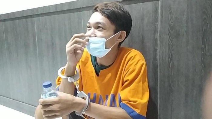Pembunuh istri siri asal Lumajang, Rival tampak santai dan tertawa sambil jongkok di salah satu ruang Humas Mapolda Jatim, saat menunggu prosesi konferensi pers, Jumat (9/12/2022).