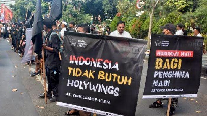Peserta aksi unjuk rasa membentangkan spanduk penolakan Holywings saat unjuk rasa di depan Gedung Grahadi, Surabaya, Selasa (5/7/2022).