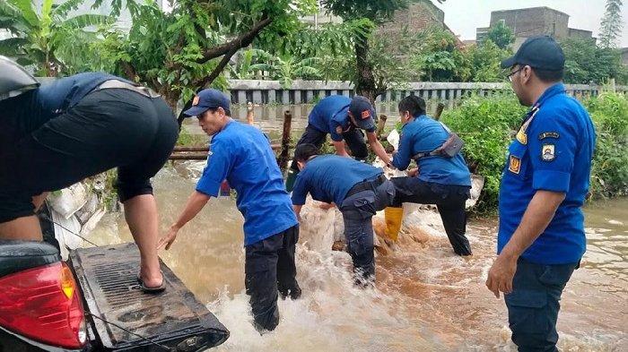 Petugas BPBD Kota Tangerang sedang menangani banjir di Kota Tangerang, Rabu (11/5/2022). Banjir ini disebabkan karena hujan intensitas tinggi mengguyur wilayah Tangerang dan sekitarnya, Selasa (10/5/2022) malam.