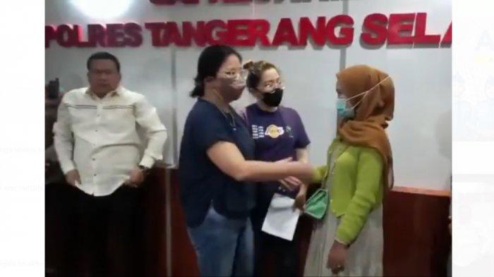 Wanita yang viral karena diduga mencuri cokelat di Alfamart bersalaman dengan Amelia, pegawai Alfamart Cisauk di Polres Tangerang Selatan, Senin (15/8/2022) malam. Kasus ini ditengahi oleh Polres Tangerang Selatan dan berakhir damai.