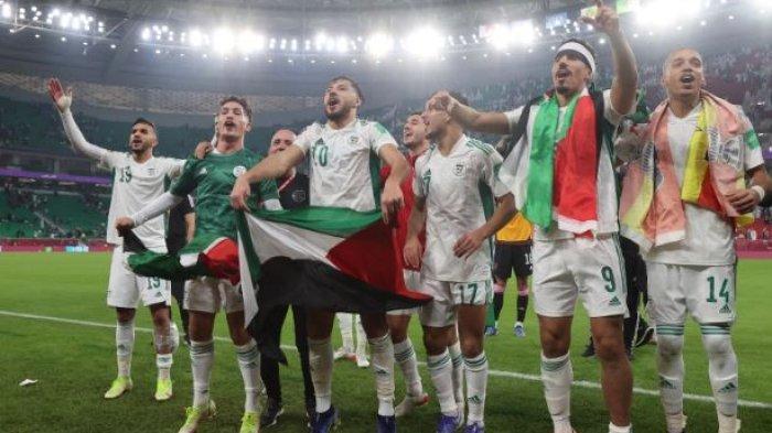 Pemain timnas Algeria mengibarkan bendera Palestina seusai memenangkan FIFA Arab Cup 2021 mengalahkan Qatar di Doha, 15 Desember 2021.