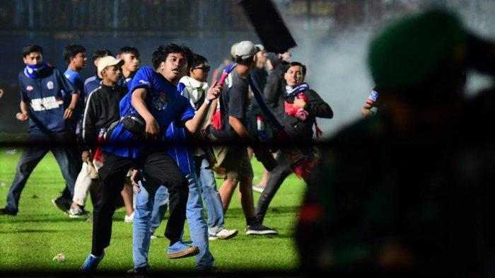 Suporter Arema FC, Aremania turun ke dalam stadion usai laga Arema FC melawan Persebaya Surabaya dalam lanjutan Liga 1 2022 di Stadion Kanjuruhan, Kabupaten Malang, Sabtu (1/10/2022).