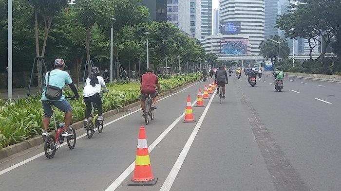 Para pesepeda memanfaatkan jalur sepeda yang dipasang sepanjang jalan raya Sudirman Thamrin, Minggu (7/3/2021)