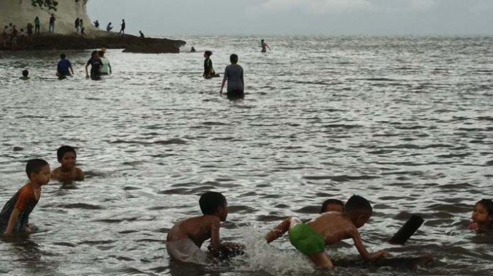 Anak-anak tampak sedang bermain di Pantai Kotajogo,