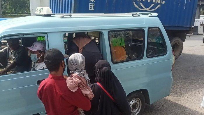 Penumpang menaiki angkot yang melintas di Jalan R. E. Martadinata, Pademangan.