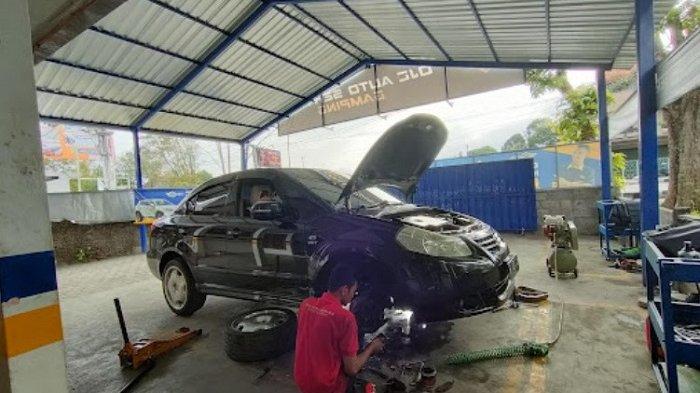 Seorang mekanik dari OJC Auto Service sedang memeriksa mobil.