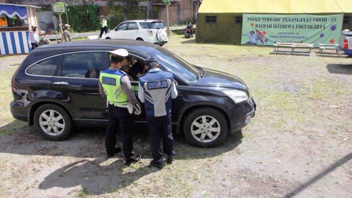 POSKO TERPADU PERBATASAN - Petuga melakukan pemeriksaan terhadap kendaraan dengan plat nomor luar wiloayah yang melintas memasuki perbatasan di Posko Terpadu Penanganan Covid-19 jalan raya Yogyakarta-Magelang, Tempel, Sleman, DI Yogyakarta, Minggu (12/4/2020) Petugas memberhentikan dan mendata asal dan tujuan penggendara, memeriksa suhu tubuh dan memeriksa penggunaan masker