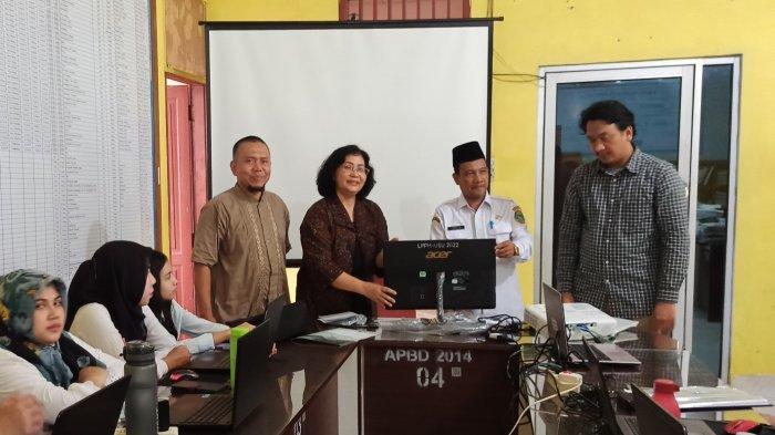 Ketua tim pengabdian Dr. Erna Budhiarti Nababan menyerahkan Perangkat Komputer