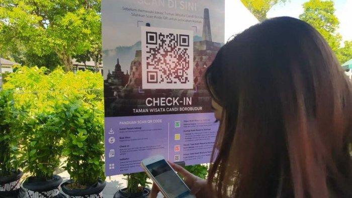 Seorang wisatawan scan QR barcode pada aplikasi PeduliLindungi sebelum masuk ke Taman Wisata