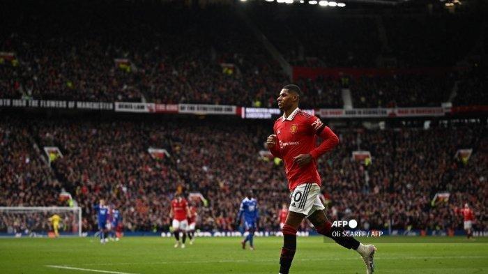Striker Inggris Manchester United Marcus Rashford merayakan gol pembuka selama pertandingan sepak bola Liga Premier Inggris antara Manchester United dan Leicester City di Old Trafford di Manchester, barat laut Inggris, pada 19 Februari 2023. Marcus Rashford dan David de Gea mengukir catatan apik saat Manchester United mengalahkan Leicester City 3-0, Minggu (19/2/2023). (Oli SCARFF / AFP)