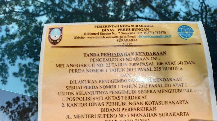 Surat tanda pemindahan kendaraan di kaca depan kendaraan yang digembok.