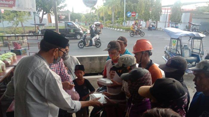 Ketua IKA Unhas Polman yang juga Wakil Bupati Natsir Rahmat membagikan makanan buka puasa