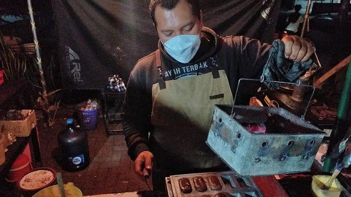 Ismail Edwin siap mengangkat kue balok dari adonan di jongkonya yang berada di halaman Kantor Desa Tanjungsari, Jalan Raya Bandung-Sumedang, Minggu (15/8/2021)