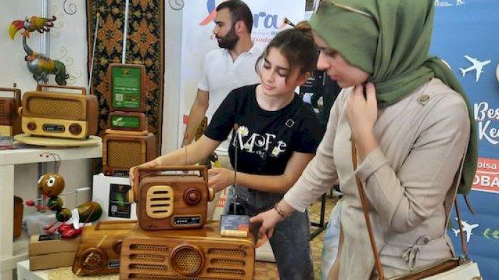 Pengunjung dari mancanegara melihat-lihat Radio Kayu produk Faber Instrumen yang menjadi official merchandise KTT G20 di Bali, November 2022
