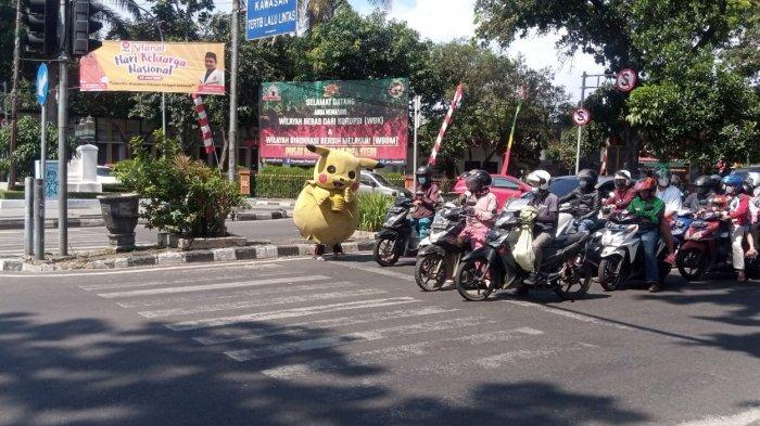 Pengamen boneka di lampu lalu lintas di Kota Bandung