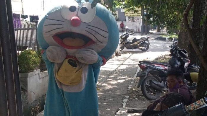 Pengamen boneka mengenakan karakter Doraemon di Kota Bandung