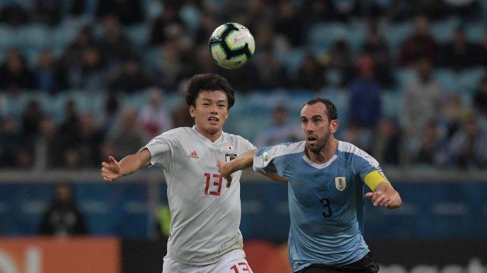Diego Godin dari Uruguay (R) dan Ayase Ueda Vie dari Jepang berebut bola pada pertandingan Copa America Football Tournament C Grup C antara Uruguay dan Jepang di Stadion Gremio Arena di Porto Alegre, Brasil, pada 20 Juni 2019.
