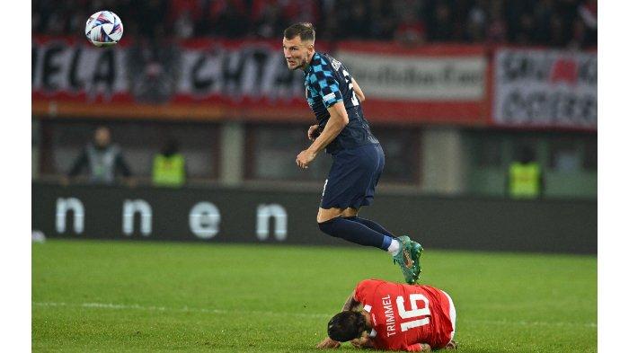 Bek Kroasia Borna Barisic (Atas) dan bek Austria Christopher Trimmel bersaing memperebutkan bola pada pertandingan sepak bola UEFA Nations League, liga A, Grup 1 antara Austria dan Kroasia di Wina, Austria, pada 25 September 2022.