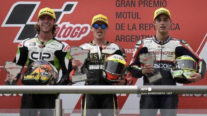 Pembalap KTM Spanyol Jaume Masia (tengah) berpose di podium dengan trofi setelah memenangkan balapan Grand Prix Moto3 Argentina, di samping runner-up KTM dari Afrika Selatan Darryn Binder (kiri) dan pembalap ketiga dari Honda, Tony Arbolino (kanan), di Termas Sirkuit de Rio Hondo di Santiago del Estero, Argentina, pada 31 Maret 2019. Masia memenangkan balapan Moto3.