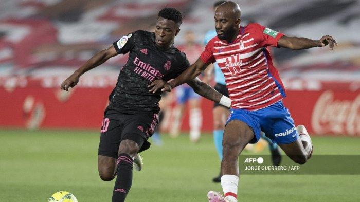 Pemain depan Real Madrid Brasil Vinicius Junior (kiri) bersaing dengan bek Granada Prancis Dimitri Foulquier selama pertandingan sepak bola liga Spanyol Granada FC melawan Real Madrid CF di stadion Nuevo Los Carmenes di Granada pada 13 Mei 2021.