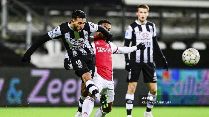 Heracles Almelo Pemain depan Belgia Ismail Azzaoui (kiri) berebut bola melawan bek Ajax Belanda Jurrien Timber selama pertandingan Eredivisie Belanda antara Heracles Almelo dan Ajax di Stadion Erve Asito di Almelo pada 13 Februari 2021.