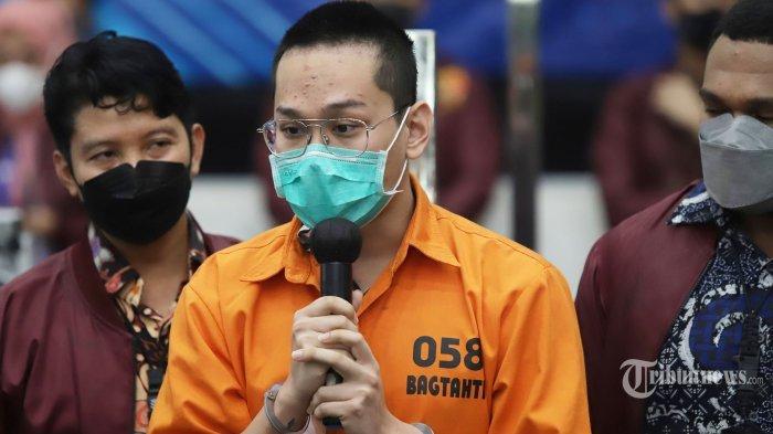 Bareskrim Polri gelar rilis kasus Binomo dengan tersangka Indra Kesuma atau Indra Kenz di Mabes Polri, Jakarta Selatan, Jumat (25/3/2022). Indra Kenz tampil dengan rambut cepak dan menggunakan baju tahanan. Selain itu, barang bukti berupa gepokan uang seratus ribu rupiah juga ditampilkan di atas meja. Jumlah duit dalam plastik itu berbeda-beda, ada yang berjumlah Rp 214 juta, Rp 925 juta, dan Rp 106 juta. Tribunnews/Jeprima