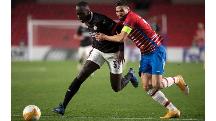 Bek PSV Eindhoven Belanda Jordan Teze (kiri) bersaing dengan gelandang Granada Spanyol Antonio Puertas selama pertandingan sepak bola grup E Liga Eropa UEFA antara Granada dan PSV Eindhoven di stadion Los Carmenes di Granada pada 3 Desember 2020.