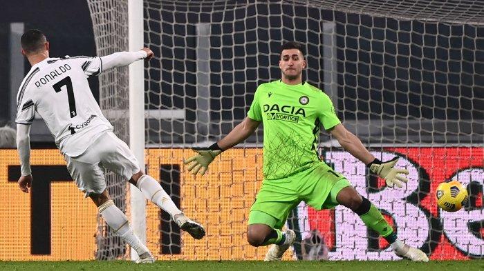 Pemain depan Juventus Portugal Cristiano Ronaldo (kiri) mencetak gol keduanya melewati kiper Udinese Argentina Juan Musso selama pertandingan sepak bola Serie A Italia Juventus vs Udinese pada 3 Januari 2021 di stadion Juventus di Turin.