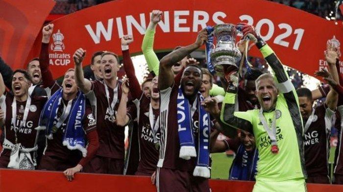 Kiper Leicester City Kasper Schmeichel dan bek Wes Morgan mengangkat trofi Piala FA setelah mengalahkan Chelsea di final Piala FA di Stadion Wembley pada Sabtu (15/5/2021) malam.