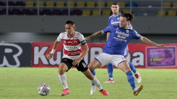 Kapten Madura United Slamet Nurcahyo dijaga ketat pemain Persib Bandung Marc Klok pada pertandingan pekan 15 Liga 1 2021-2022 yang berakhir dengan skor 0-1 di Stadion Manahan Solo, Sabtu (4/12/2021) malam.