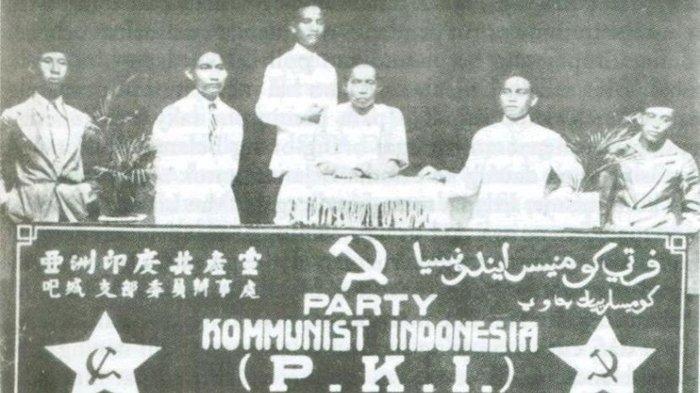 Para tokoh PKI sedang memegang bendera Partai Komunis Indonesia