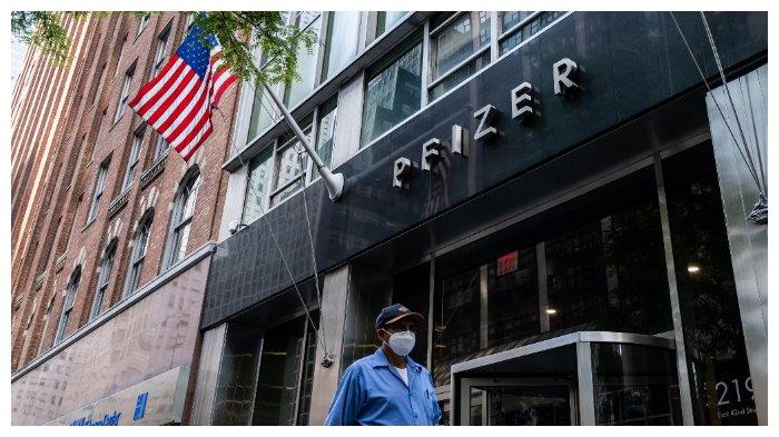 Seorang pria bermasker berjalan melewati markas perusahaan vaksin, Pfizer Inc., di New York, Amerika Serikat, pada Rabu (22 Juli 2020).