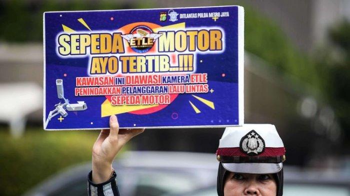 Petugas kepolisian dari direktorat lalu lintas (Ditlantas) Polda Metro Jaya menyosialisasikan penerapan sistem tilang elektronik atau electronic traffic law enforcement (ETLE) untuk kendaraan roda dua atau motor di Simpang Sarinah, Thamrin, Jakarta Pusat, Senin (3/2/2020). Untuk saat ini sistem ETLE untuk pengendara sepeda motor fokus pada penindakan tiga pelanggaran, yakni penggunaan helm, menerobos traffic light, dan melanggar marka jalan. Penerapan aturan tersebut telah resmi diberlakukan mulai Sabtu (1/2/2020)