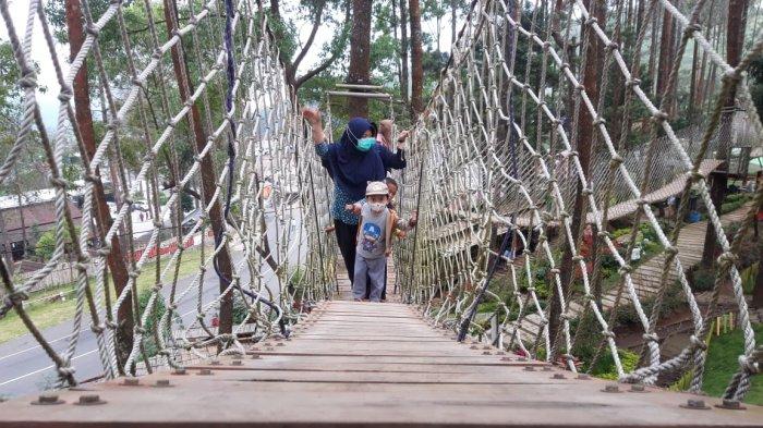 Pengunjung saat melewati jalan layang tali di The Lawu Park Tawangmenggu, Karanganyar, Sabtu (29/5/2021).